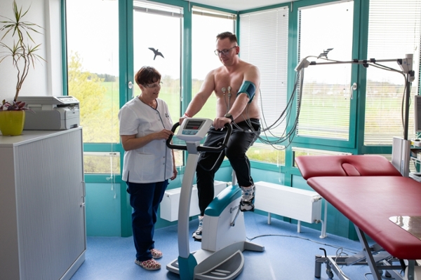 Mann mit EKG-Paddles auf dem Oberkörper auf einem Fahrradergometer Mann mit EKG-Paddles auf dem Oberkörper auf einem Fahrradergometer